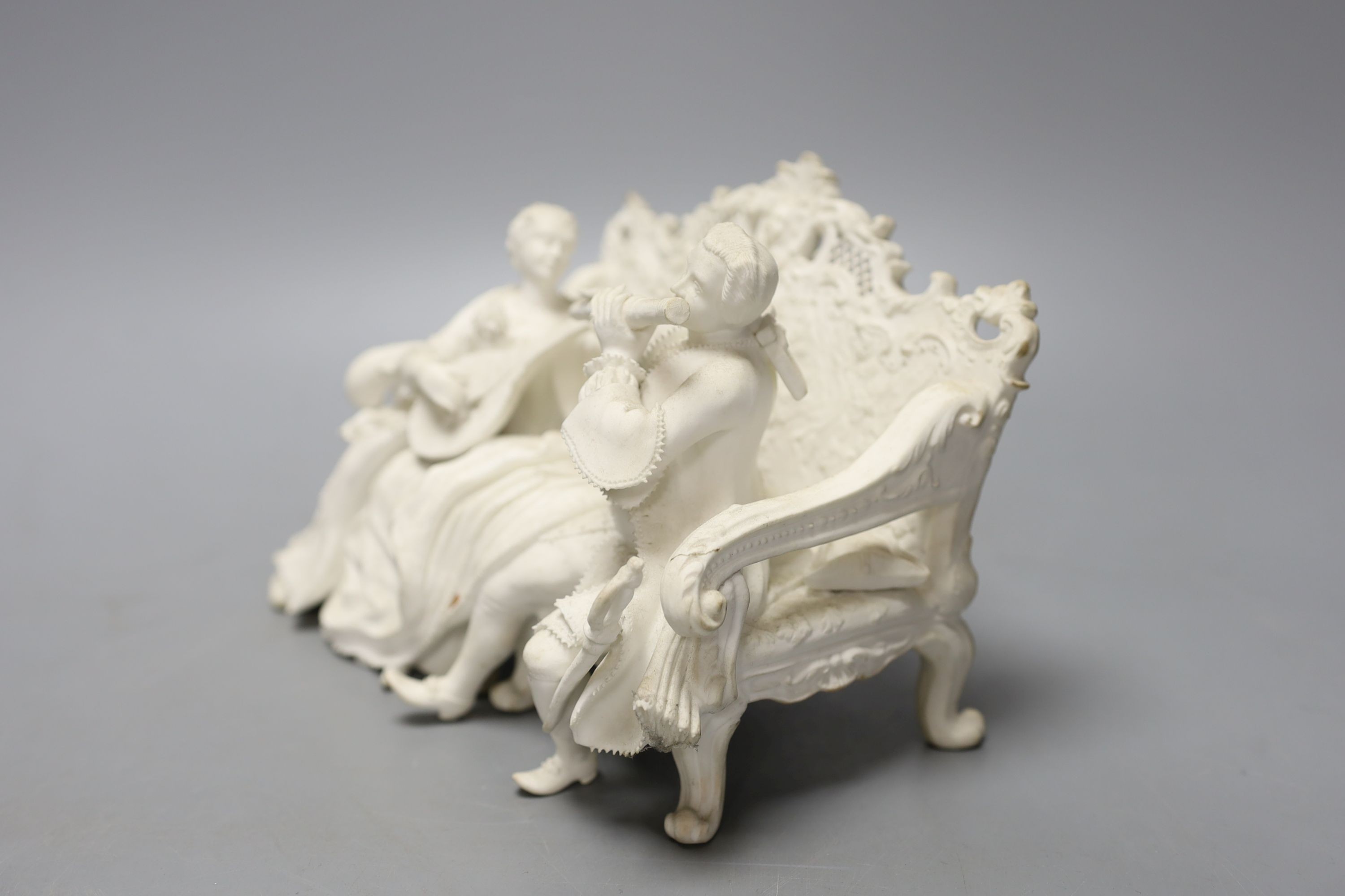 19th century English biscuit group of a woman with a mandolin and a man with a flute seated on an elaborate settee, 20 cm wide